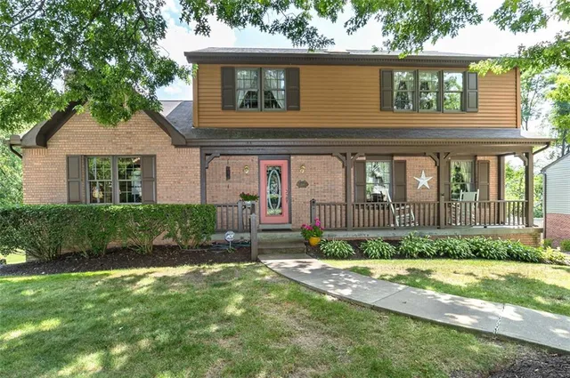 a front view of a house with a yard and trees