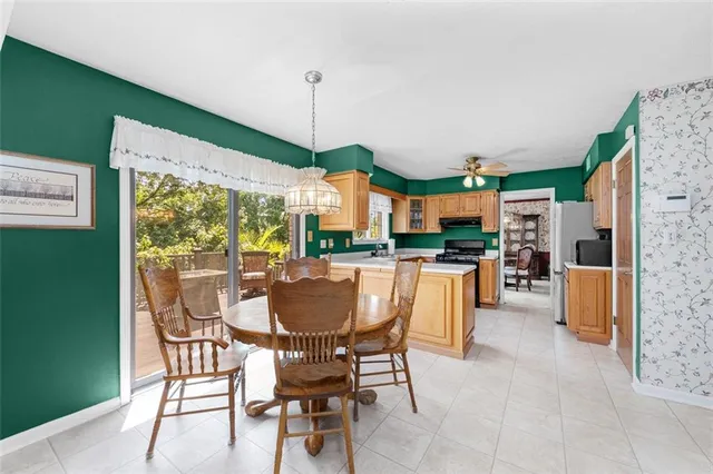 a dining room filled with furniture and a floor to ceiling window