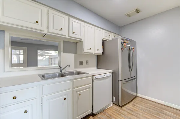 a kitchen with appliances a sink and cabinets