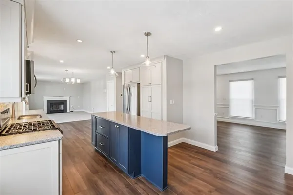 a kitchen with kitchen island granite countertop a sink stainless steel appliances and cabinets