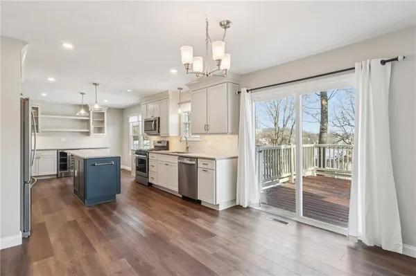 a view of a kitchen with refrigerator and wooden floor