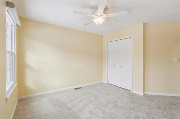 an empty room with a window and a ceiling fan