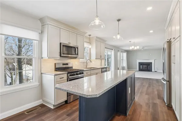 a large kitchen with granite countertop a stove oven and a sink with granite countertops