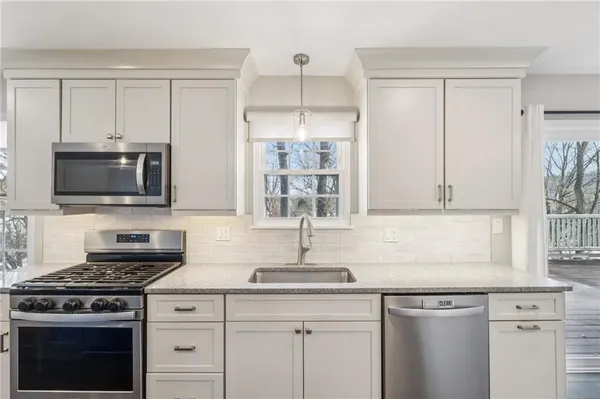 a kitchen with stainless steel appliances granite countertop a sink stove and microwave