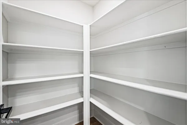 an empty room with wooden floor chandelier and windows