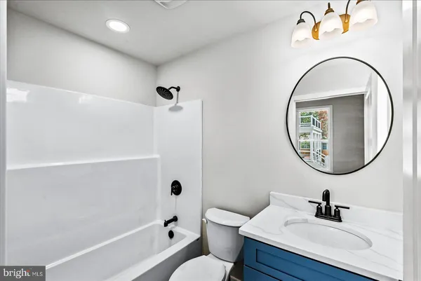 an empty room with wooden floor and ceiling fan