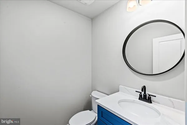 an empty room with wooden floor chandelier fan and windows