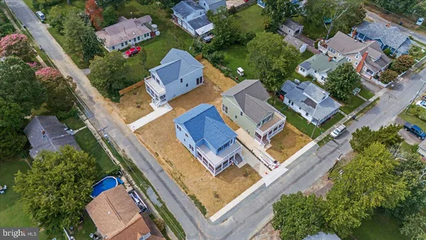 an aerial view of residential houses with outdoor space and street view