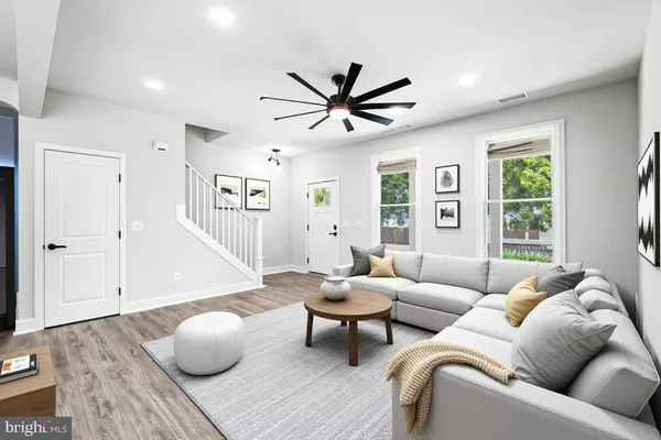 an empty room with wooden floor fan and windows