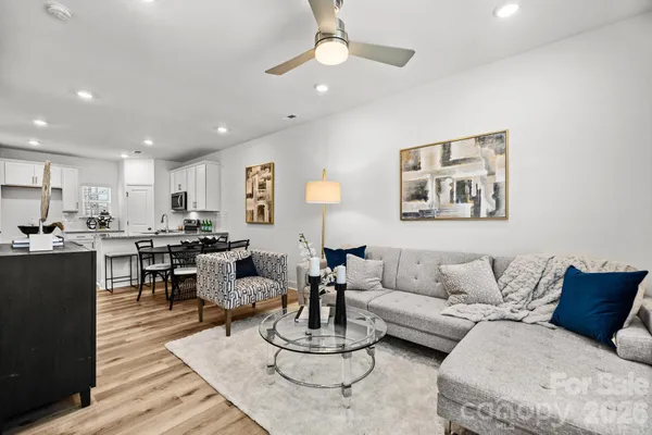 a living room with furniture and a view of kitchen