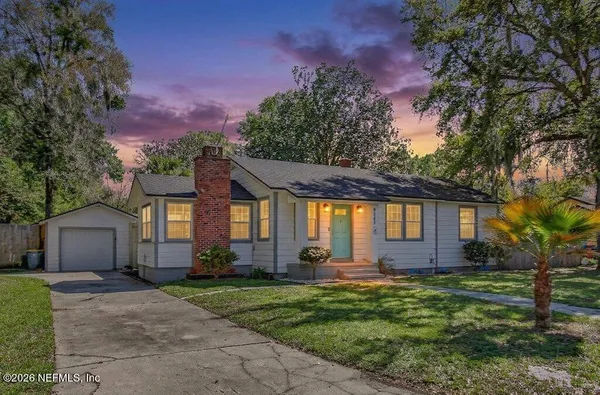 a front view of a house with a yard and a garage