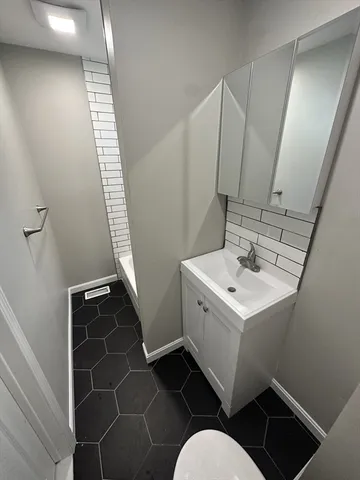 a bathroom with a sink a toilet and a mirror