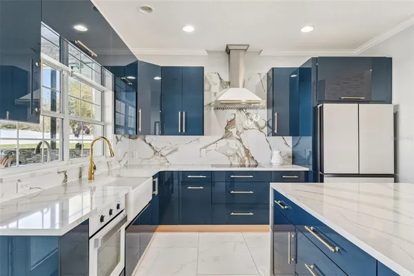 a kitchen with stainless steel appliances kitchen island granite countertop a refrigerator a sink and a stove
