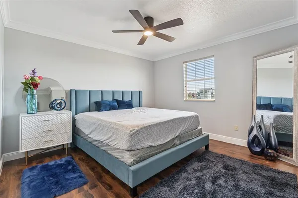 a bed sitting in a bedroom next to a window and a chandelier
