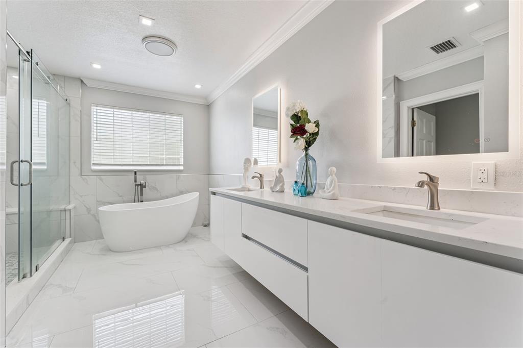 6053 New Hope Road Orlando, FL 32824 - Photo 20 of 40 a bathroom with a double vanity sink a mirror and a bathtub