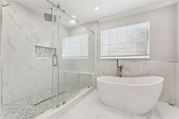 a white bath tub sitting next to a shower