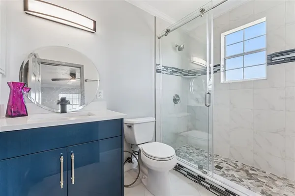 a bathroom with a sink toilet vanity and shower