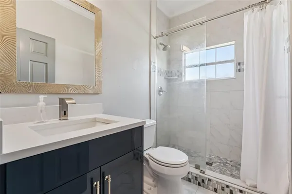 a bathroom with a sink a toilet and shower