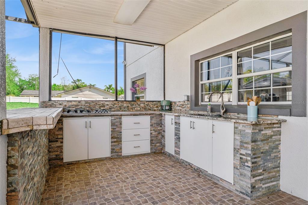 6053 New Hope Road Orlando, FL 32824 - Photo 26 of 40 a room with granite countertop a sink and a large mirror