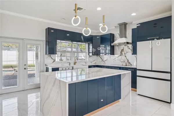 a kitchen with stainless steel appliances kitchen island granite countertop a refrigerator a stove and a sink with large countertops