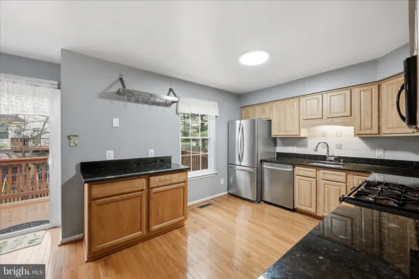 a kitchen with stainless steel appliances granite countertop a stove a sink dishwasher and a refrigerator