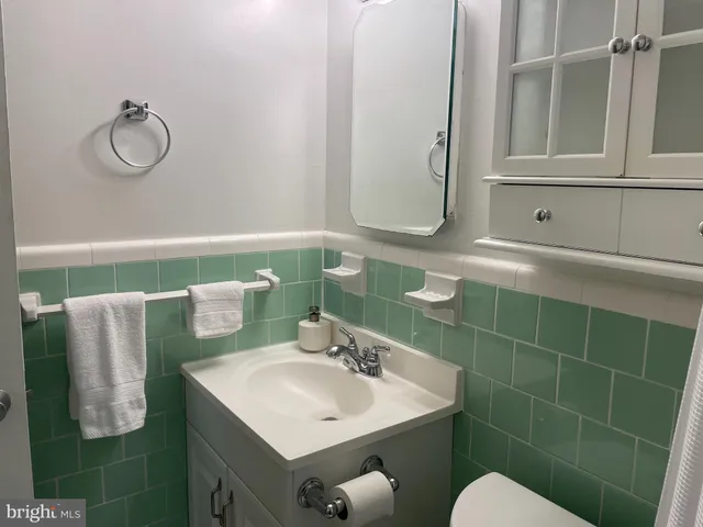 a bathroom with a sink vanity mirror and toilet