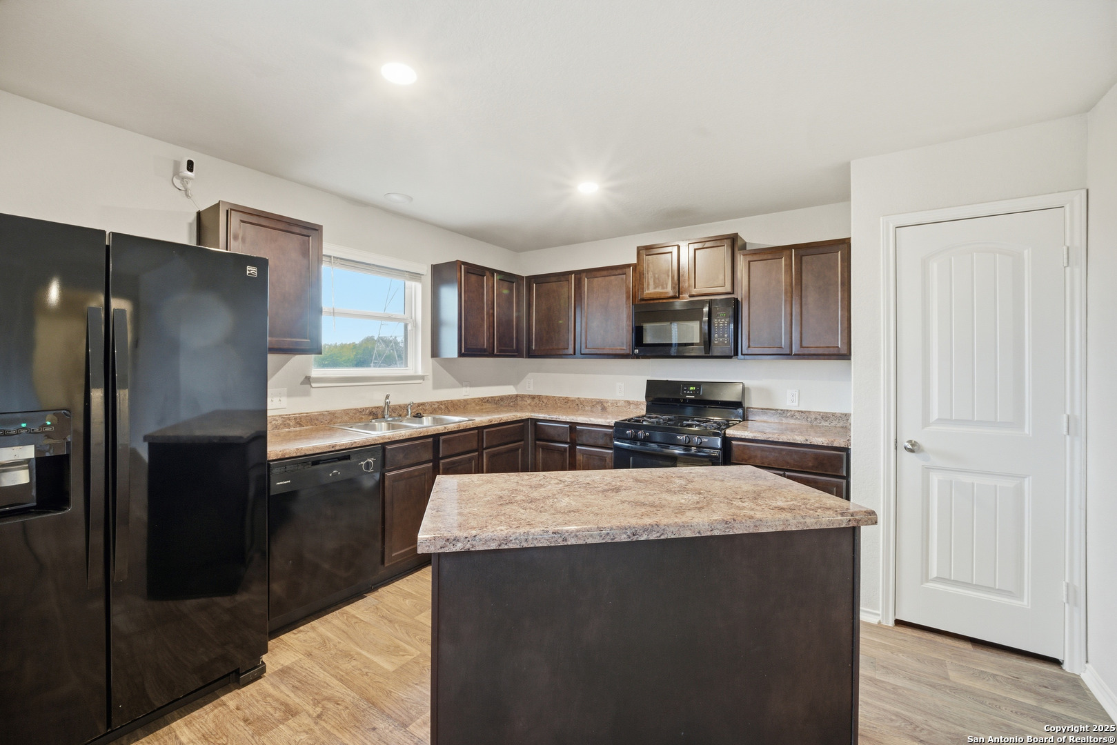 5803 Still River San Antonio, TX 78244 - Photo 2 of 15 a kitchen with granite countertop a refrigerator and a stove top oven