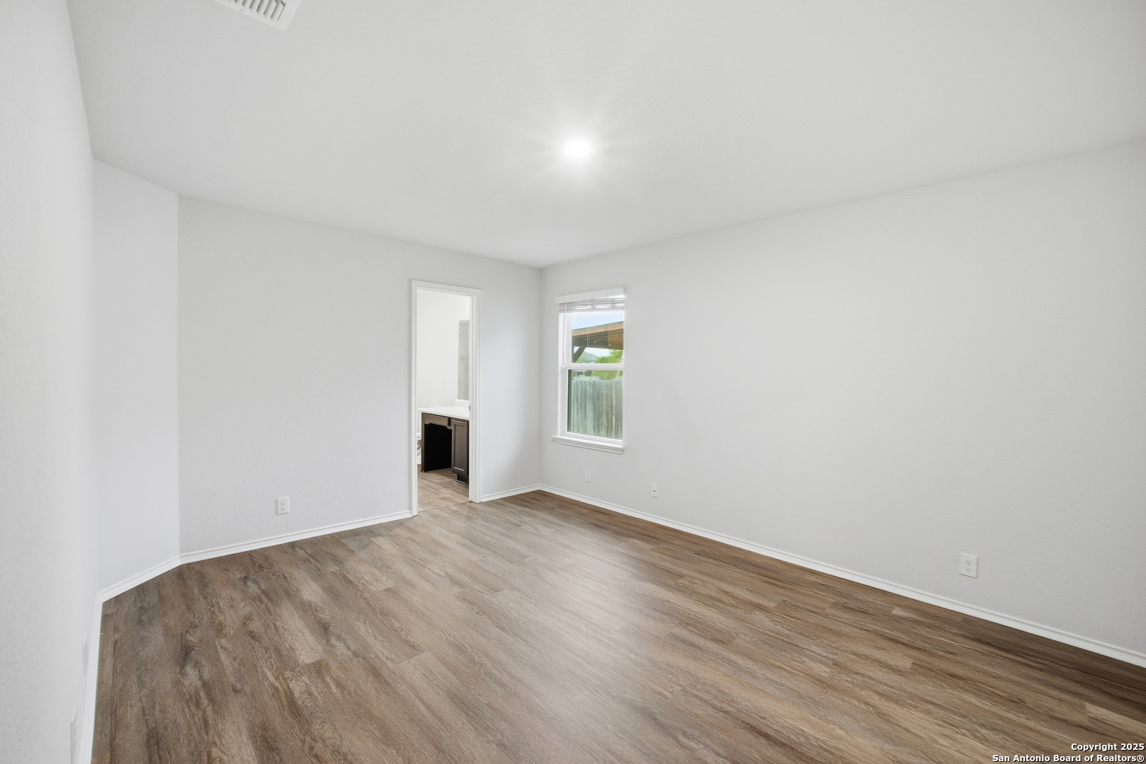 5803 Still River San Antonio, TX 78244 - Photo 8 of 15 a view of an empty room with wooden floor and a window