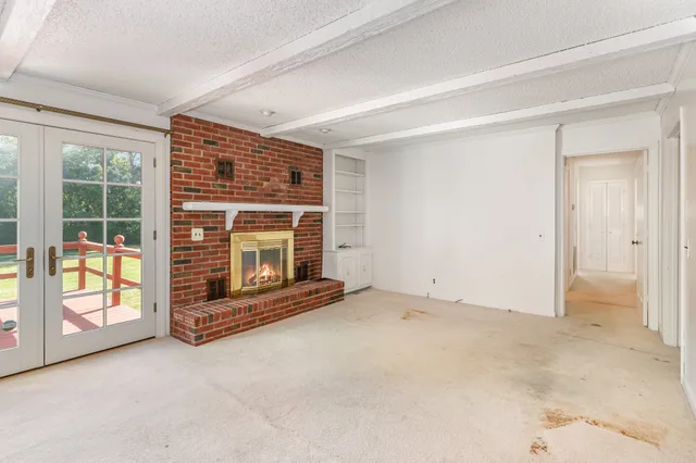 an empty room with fireplace and a window