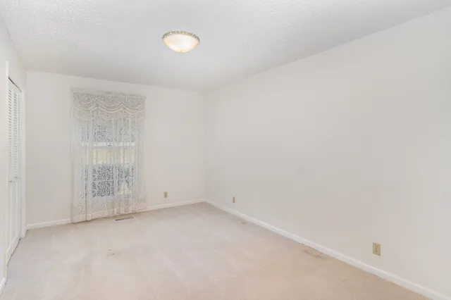 an empty room with white walls and windows