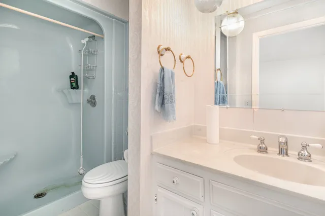 a bathroom with a granite countertop toilet and a mirror