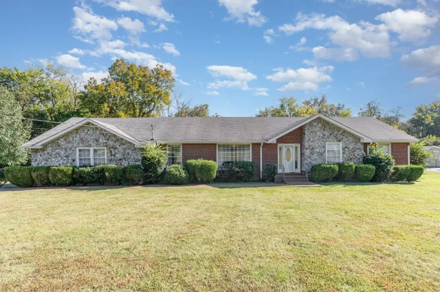 a front view of a house with yard and green space