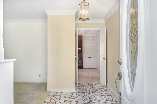 a view of a hallway with wooden floor and a bathroom