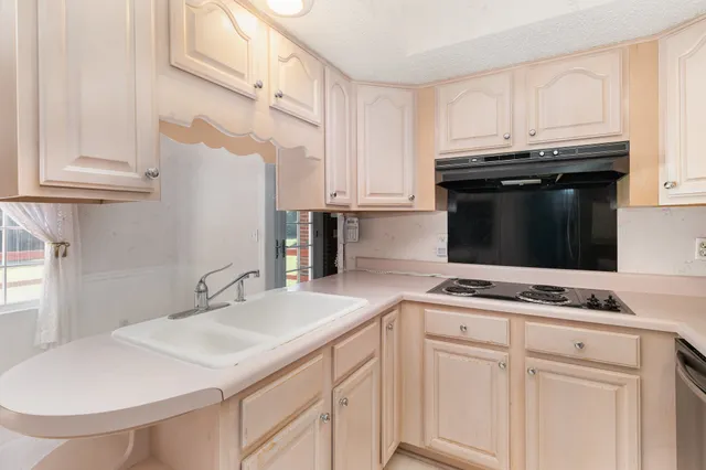 a kitchen with granite countertop a sink and cabinets