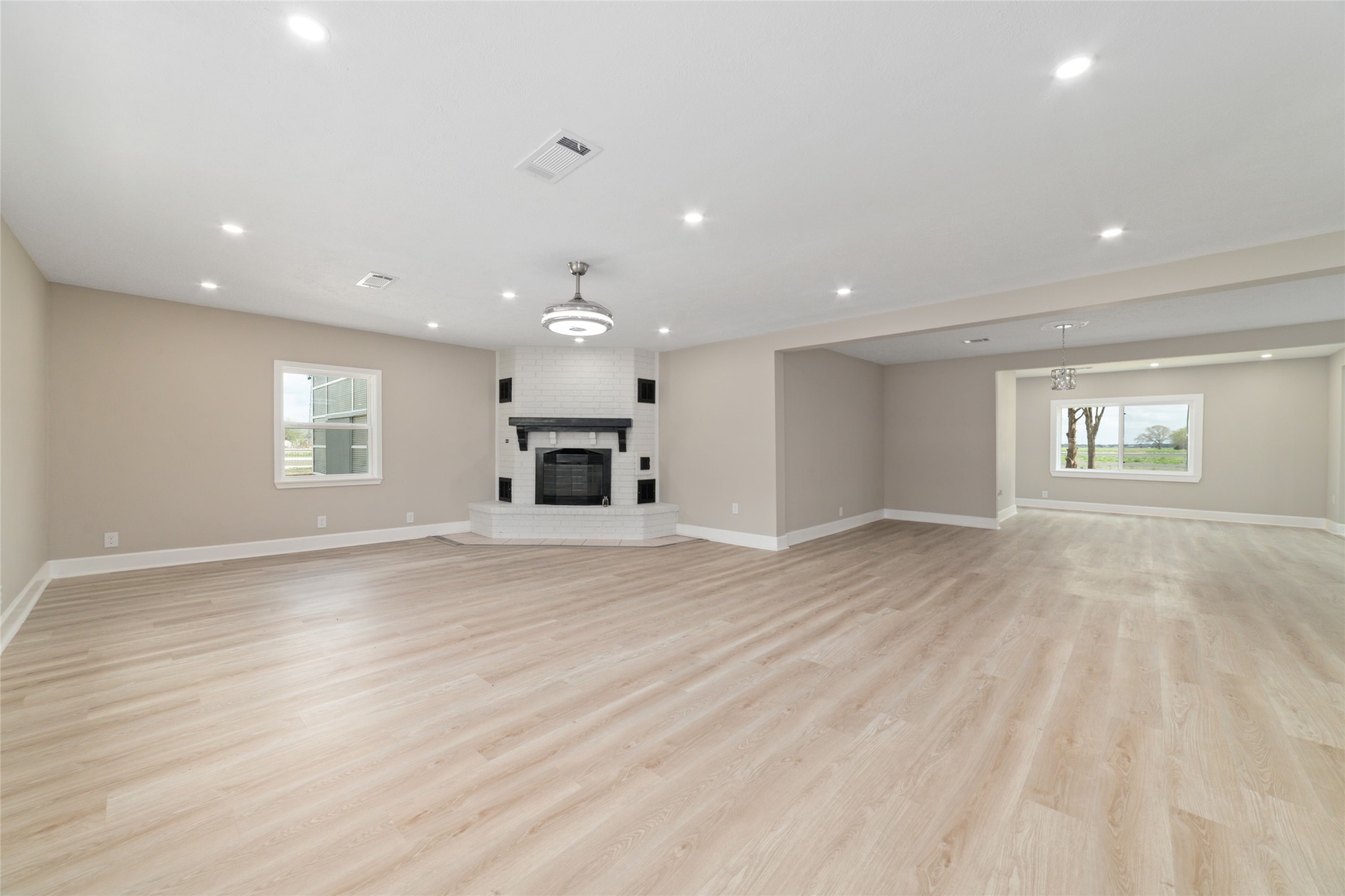 13431 Vrlla Road Guy, TX 77444 - Photo 3 of 32 an empty room with wooden floor a ceiling fan and windows
