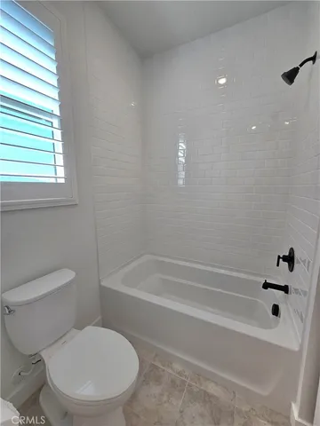 a white toilet sitting next to a bath tub