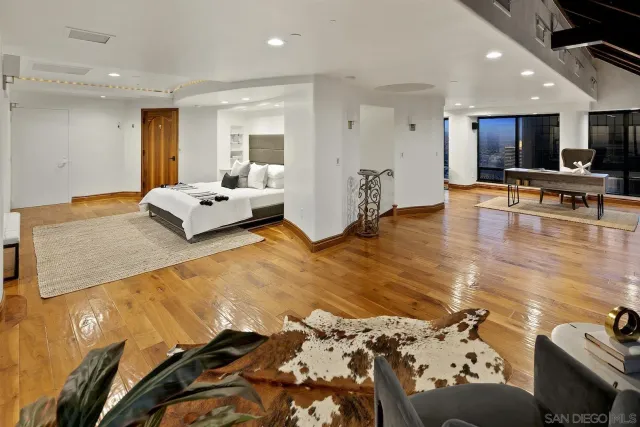 a bedroom with a bed a couch and a view of kitchen