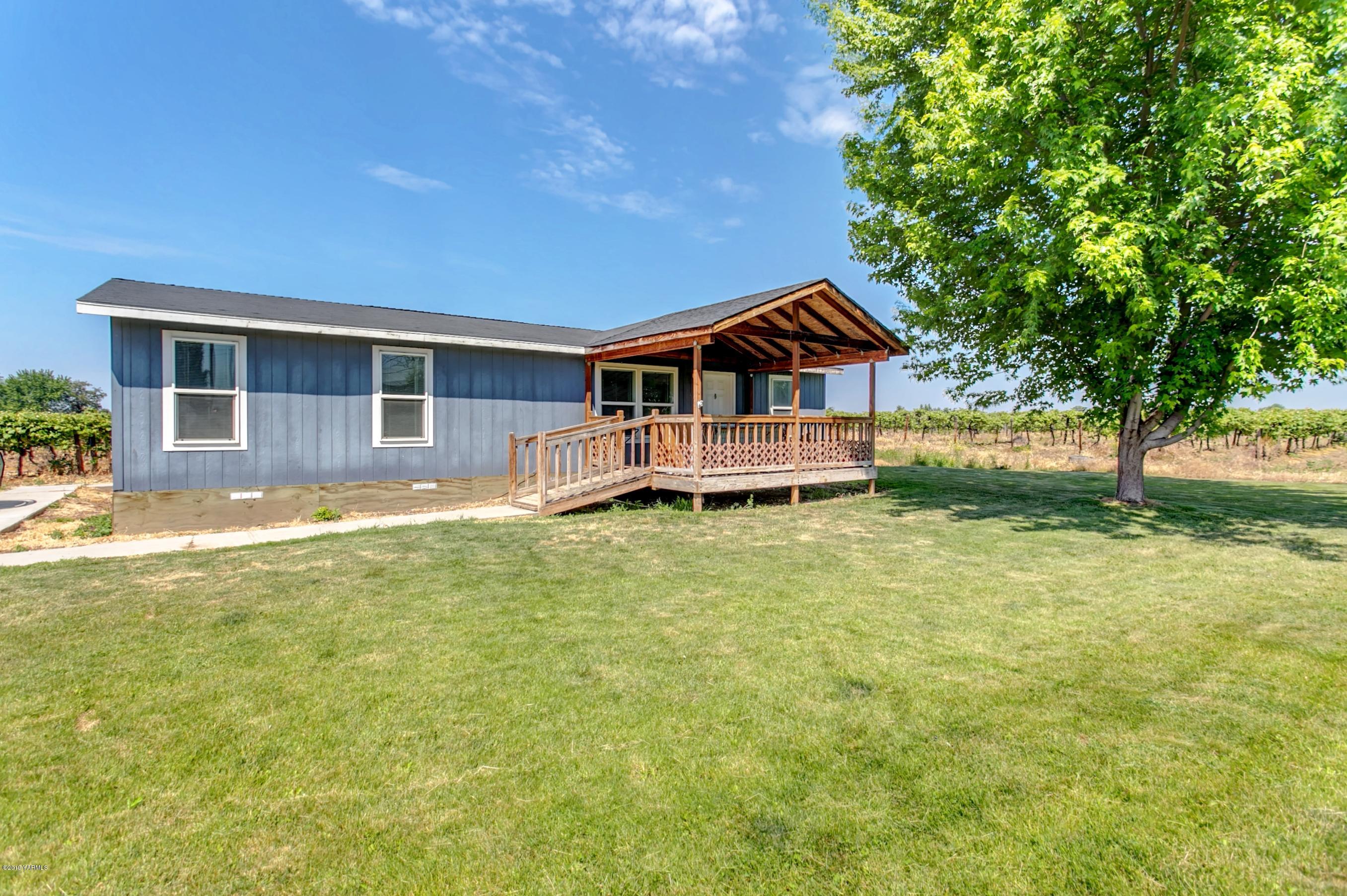 1263 Mountainview Road Grandview, WA 98930 - Photo 1 of 19 a front view of a house with a yard table and chairs