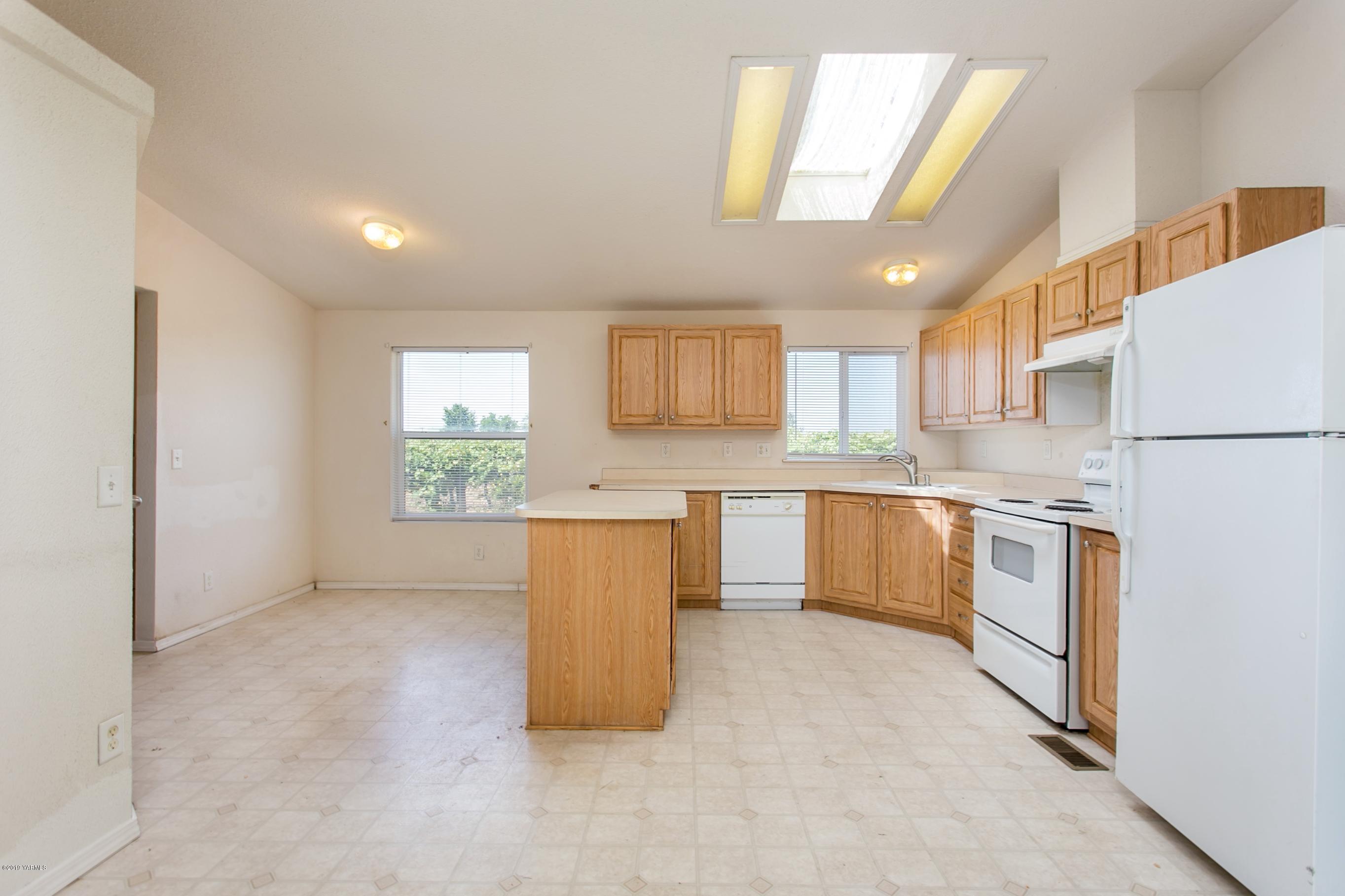 1263 Mountainview Road Grandview, WA 98930 - Photo 6 of 19 a kitchen with white cabinets and white appliances