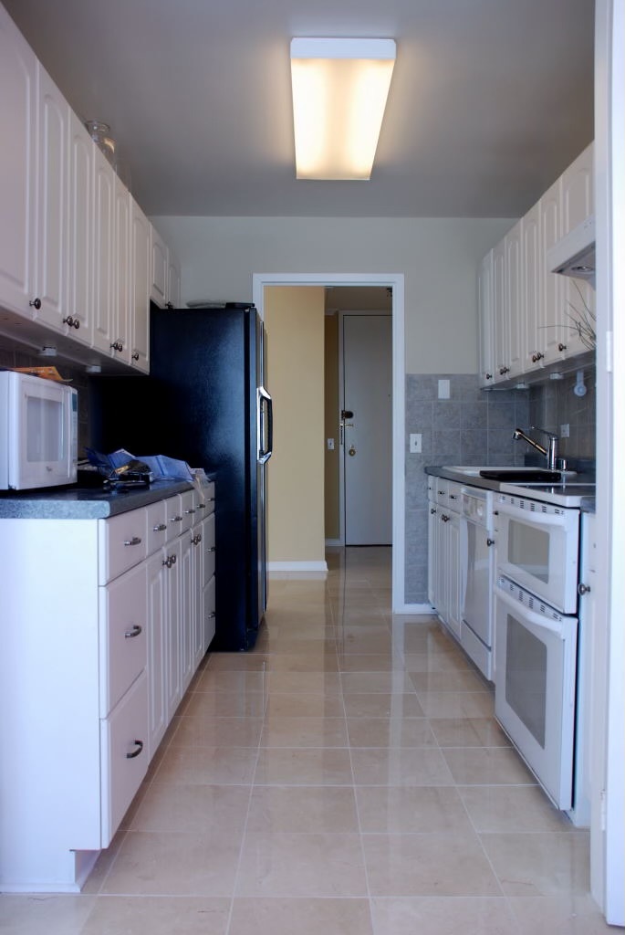 5445 North Sheridan Road, Unit 3012 Chicago, IL 60640 - Photo 4 of 8 a kitchen with a sink stove and cabinets