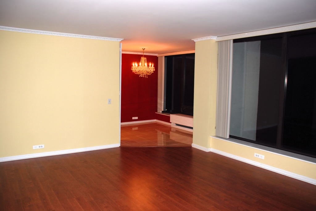 5445 North Sheridan Road, Unit 3012 Chicago, IL 60640 - Photo 6 of 8 an empty room with wooden floor and windows