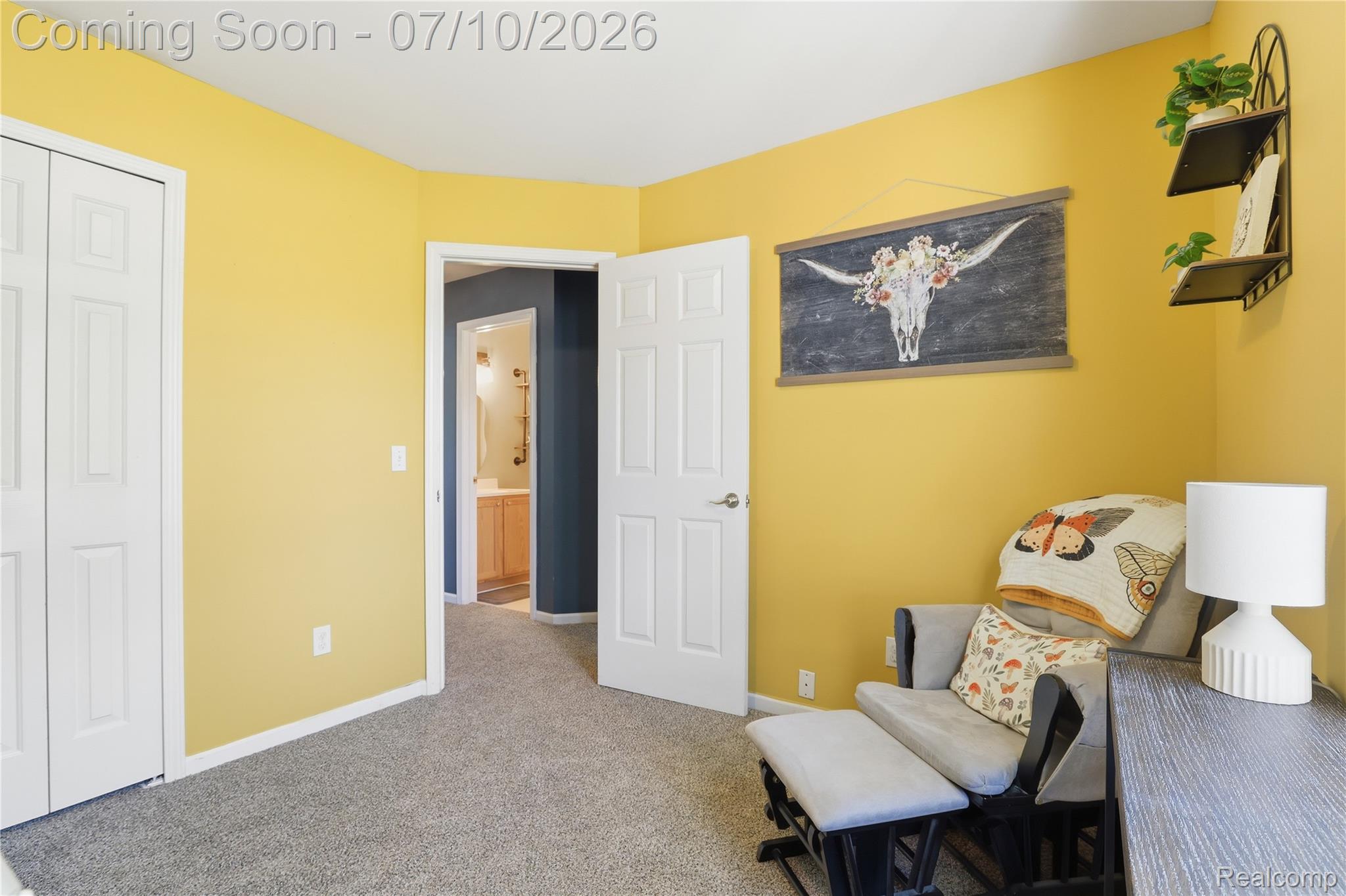 5275 East Maple Avenue Grand Blanc, MI 48439 - Photo 15 of 53 Bedroom featuring a neutral carpet, bright yellow walls, and a white bi-fold closet door