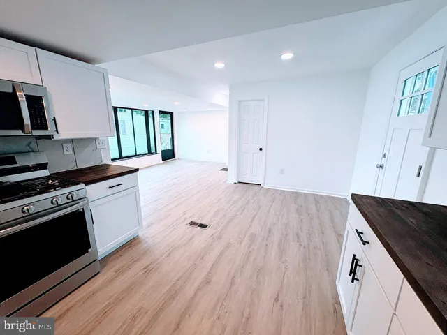 a kitchen with granite countertop wooden floors and white stainless steel appliances