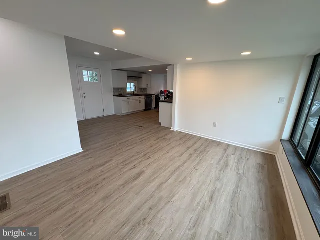 a view of empty room with wooden floor and electronic appliances