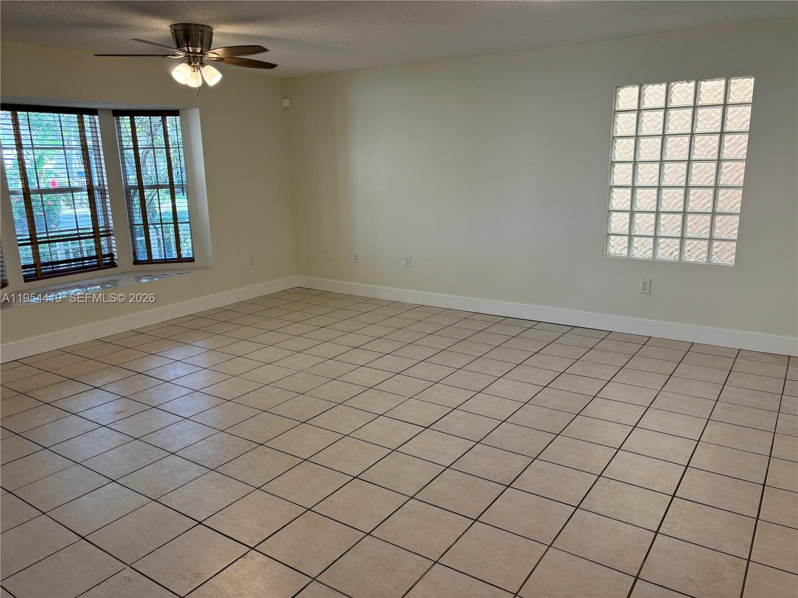 11132 Southwest 153rd Court Miami, FL 33196 - Photo 3 of 33 an empty room with windows and ceiling fan