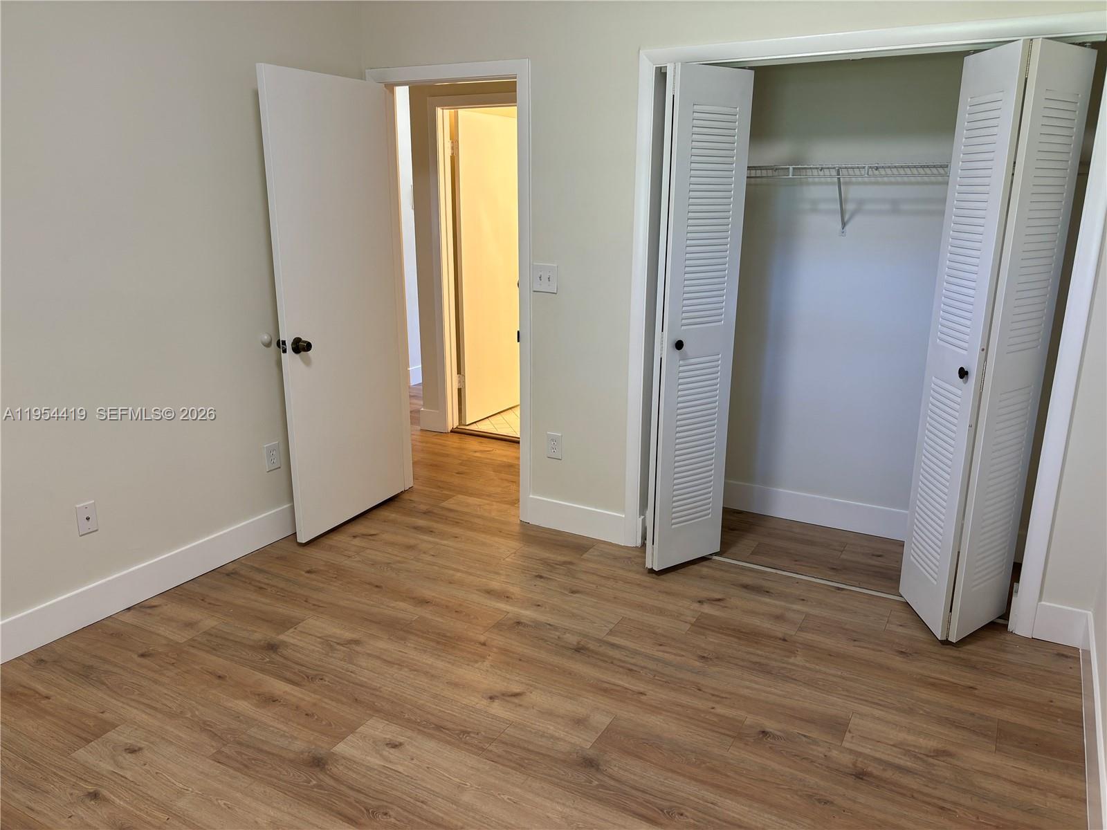 11132 Southwest 153rd Court Miami, FL 33196 - Photo 5 of 33 an empty room with wooden floor and closet
