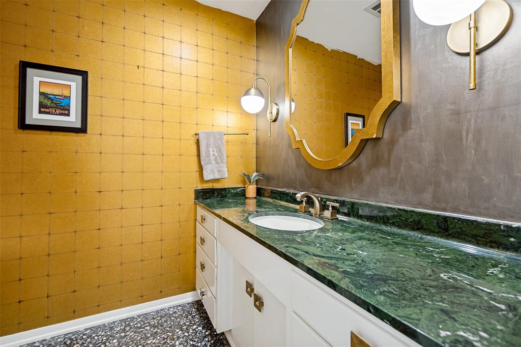 4614 Ridgeside Drive Dallas, TX 75244 - Photo 26 of 30 Vanity with integrated sink, green stone countertop, and brass-tone fixtures