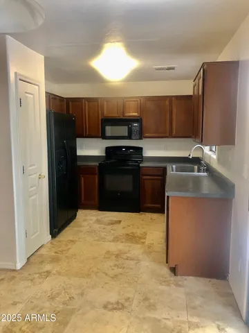 a kitchen with stainless steel appliances granite countertop a refrigerator and a sink