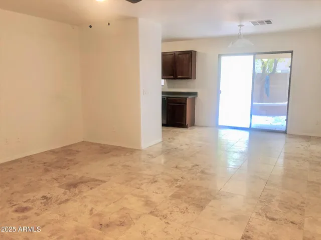 an empty room with kitchen view and a window