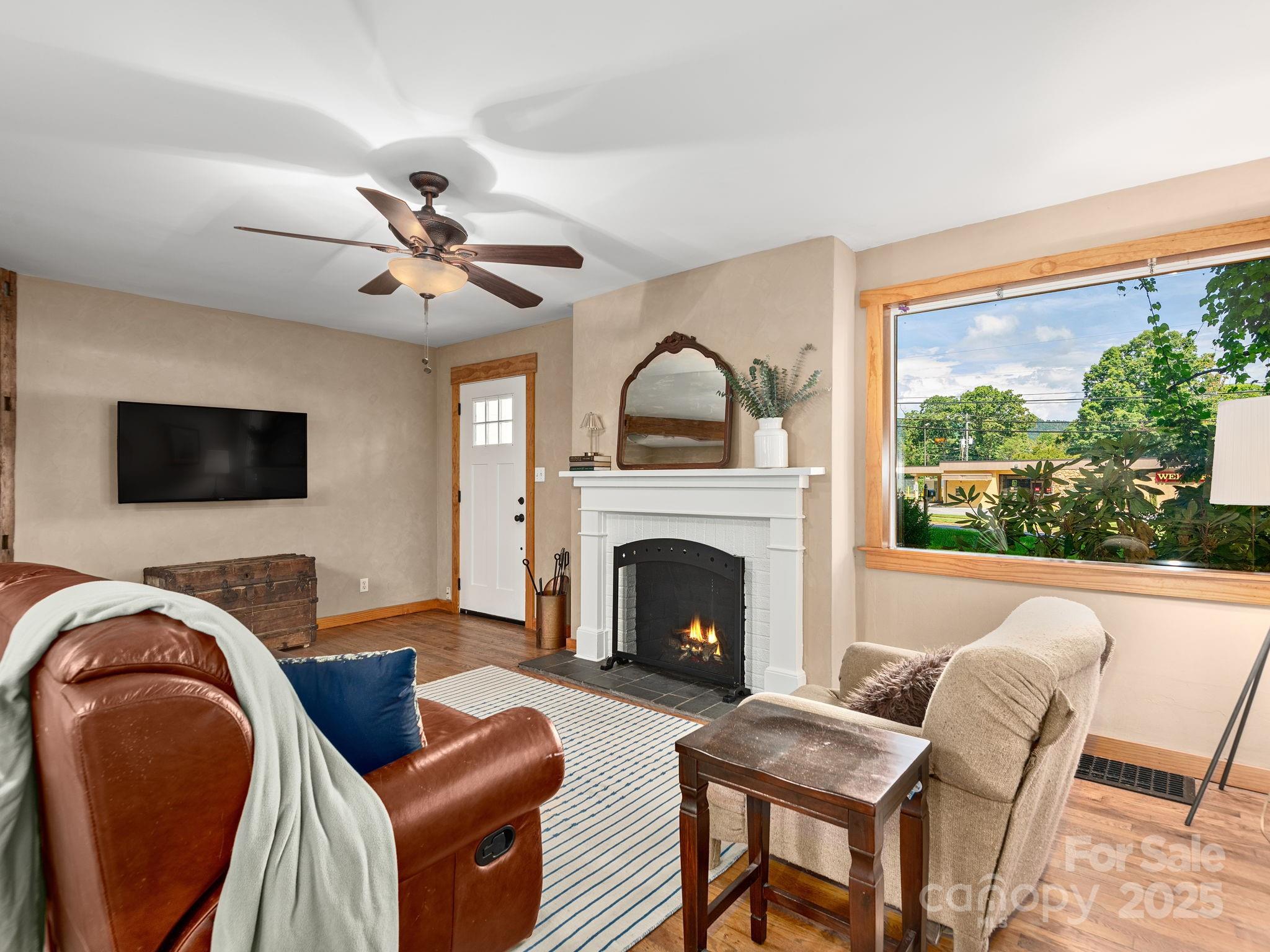 915 Tunnel Road Asheville, NC 28805 - Photo 2 of 22 a living room with furniture a fireplace and a floor to ceiling window